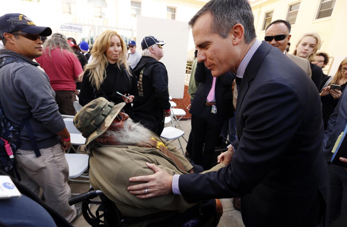 Los Angeles Mayor Eric Garcetti, right, talks with Lone Wolf, left, a homeless Vietnam veteran at the West Los Angeles Veterans Affairs campus.