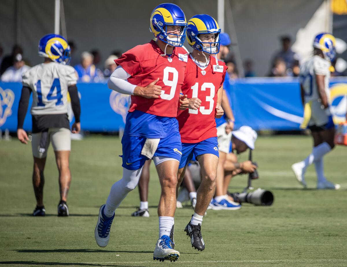 Rams quarterbacks Matthew Stafford (left) and Stetson Bennett run 