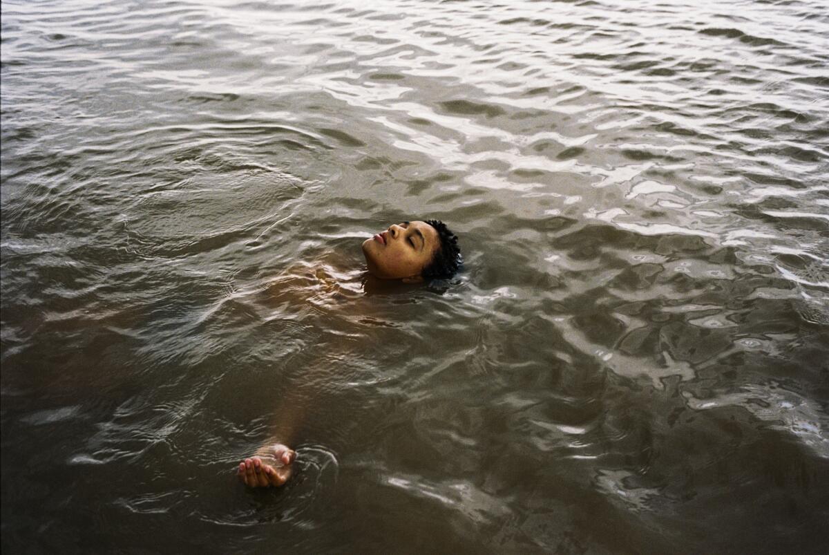 A young woman floats in the water.