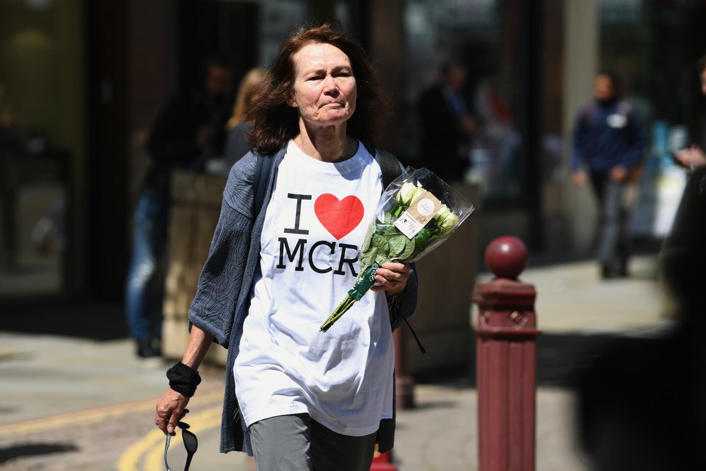 A woman makes her way to lay flowers in St. Ann Square in Manchester, England, on May 23, 2017, to honor the victims of the previous night's terror attack.