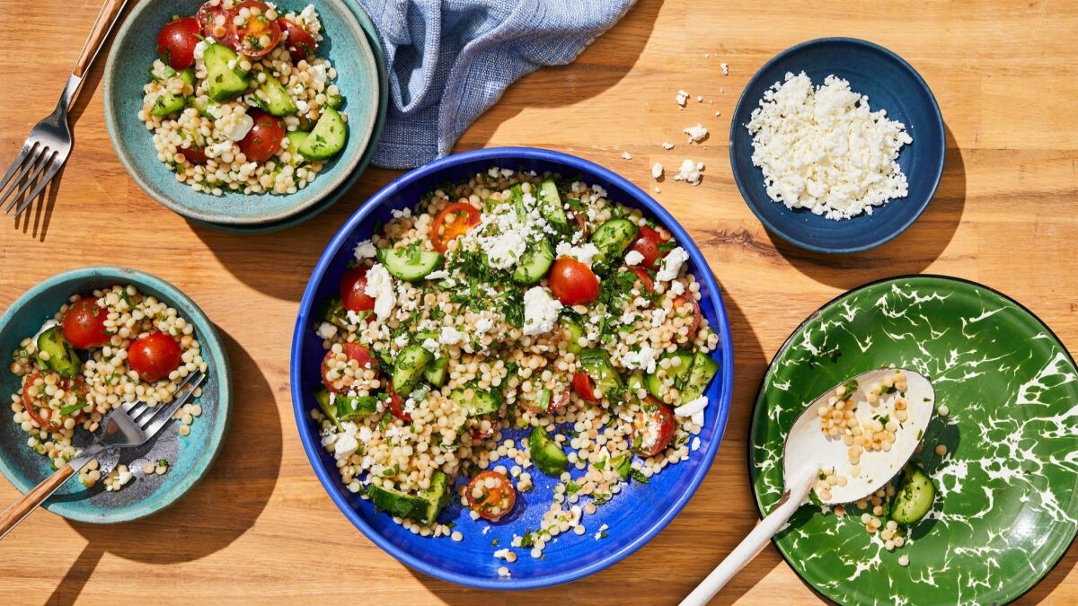 Tender Israeli couscous soaks up a tart vinaigrette and plays well with crunchy, cold cucumbers, cherry tomatoes and feta. Prop styling by Nidia Cueva.