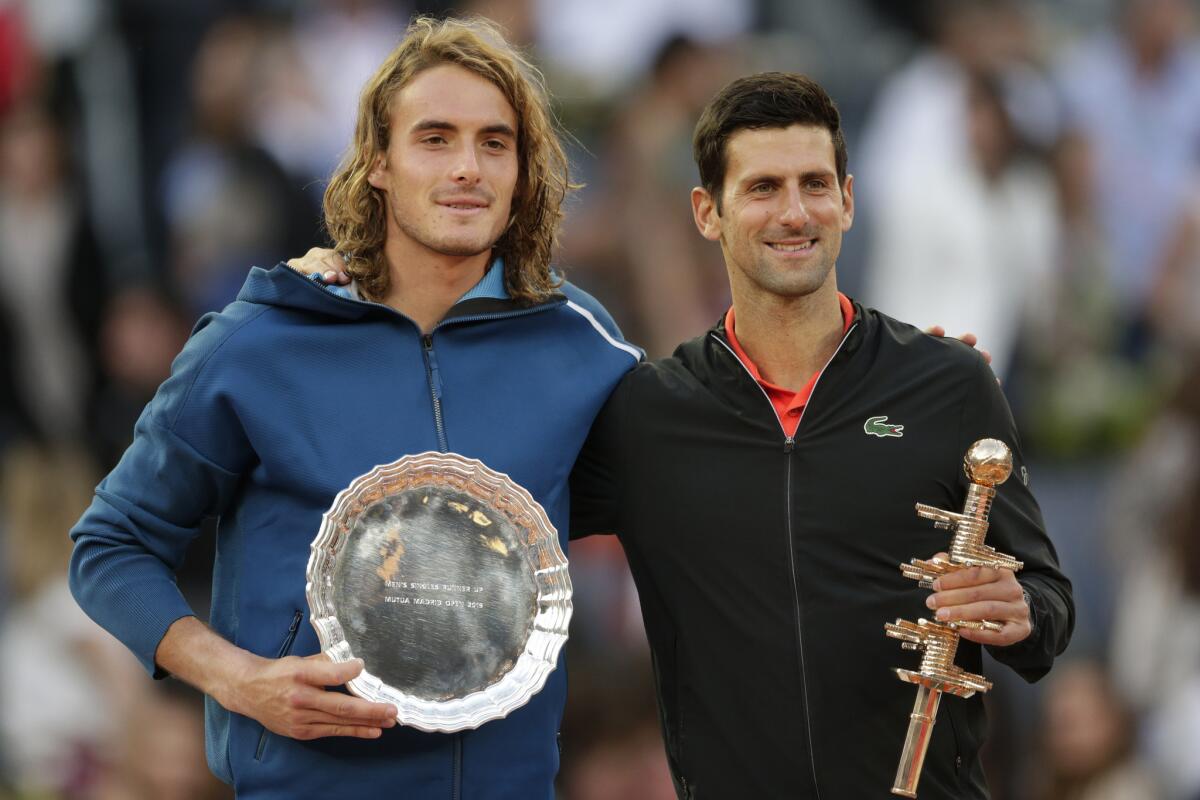 El serbio Novak Djokovic, derecha, sostiene el trofeo tras ganar la final del Abierto de Madrid por 6-3, 6-4 contra el griego Stefanos Tsitsipas, izquierda, en Madrid.