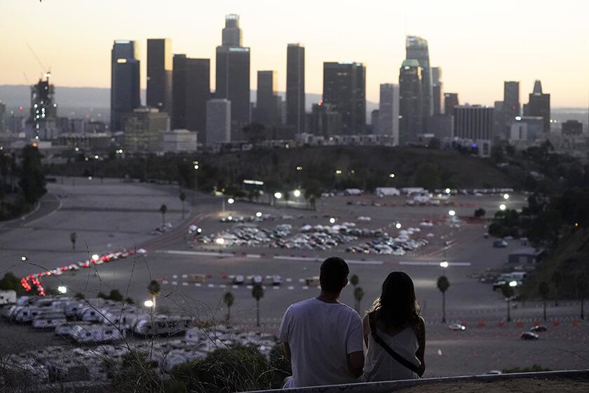Visitors watch the sunset over a COVID-19 vaccination site at Dodger Stadium on Friday.