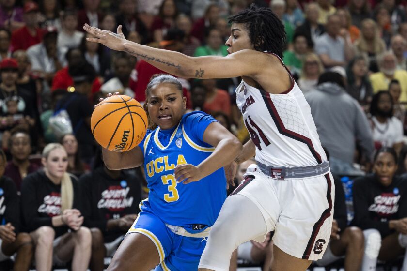 UCLA's Londynn Jones (3) drives the ball around South Carolina's Kierra Fletcher (41) in the first half of a Sweet 16 college basketball game at the NCAA Tournament in Greenville, S.C., Saturday, March 25, 2023. (AP Photo/Mic Smith)