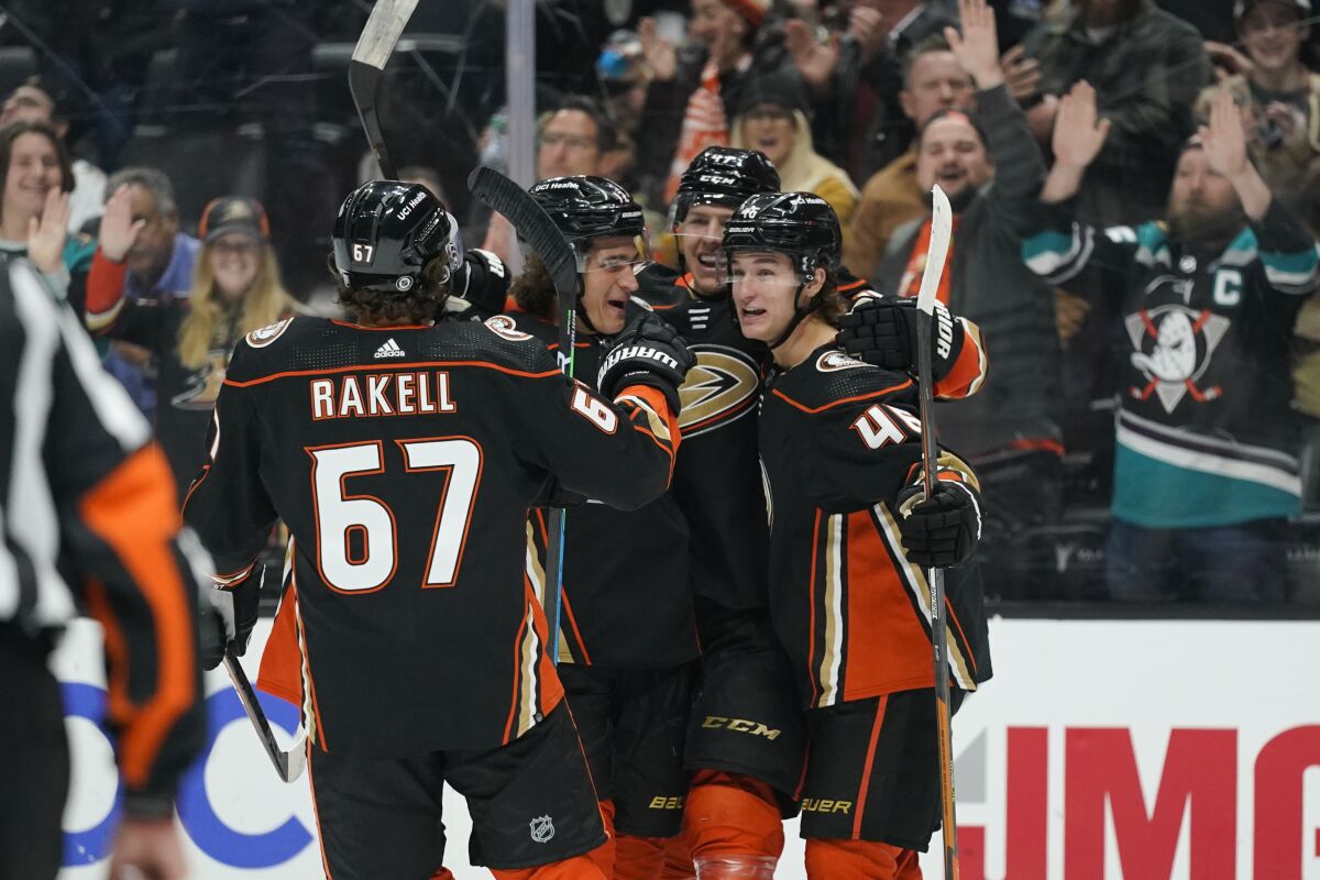 Anaheim Ducks' Trevor Zegras, from right, Hampus Lindholm, Sonny Milano and Rickard Rakell celebrate a goal by Zegras during the second period of an NHL hockey game against the Vegas Golden Knights Wednesday, Dec. 1, 2021, in Anaheim, Calif. (AP Photo/Jae C. Hong)