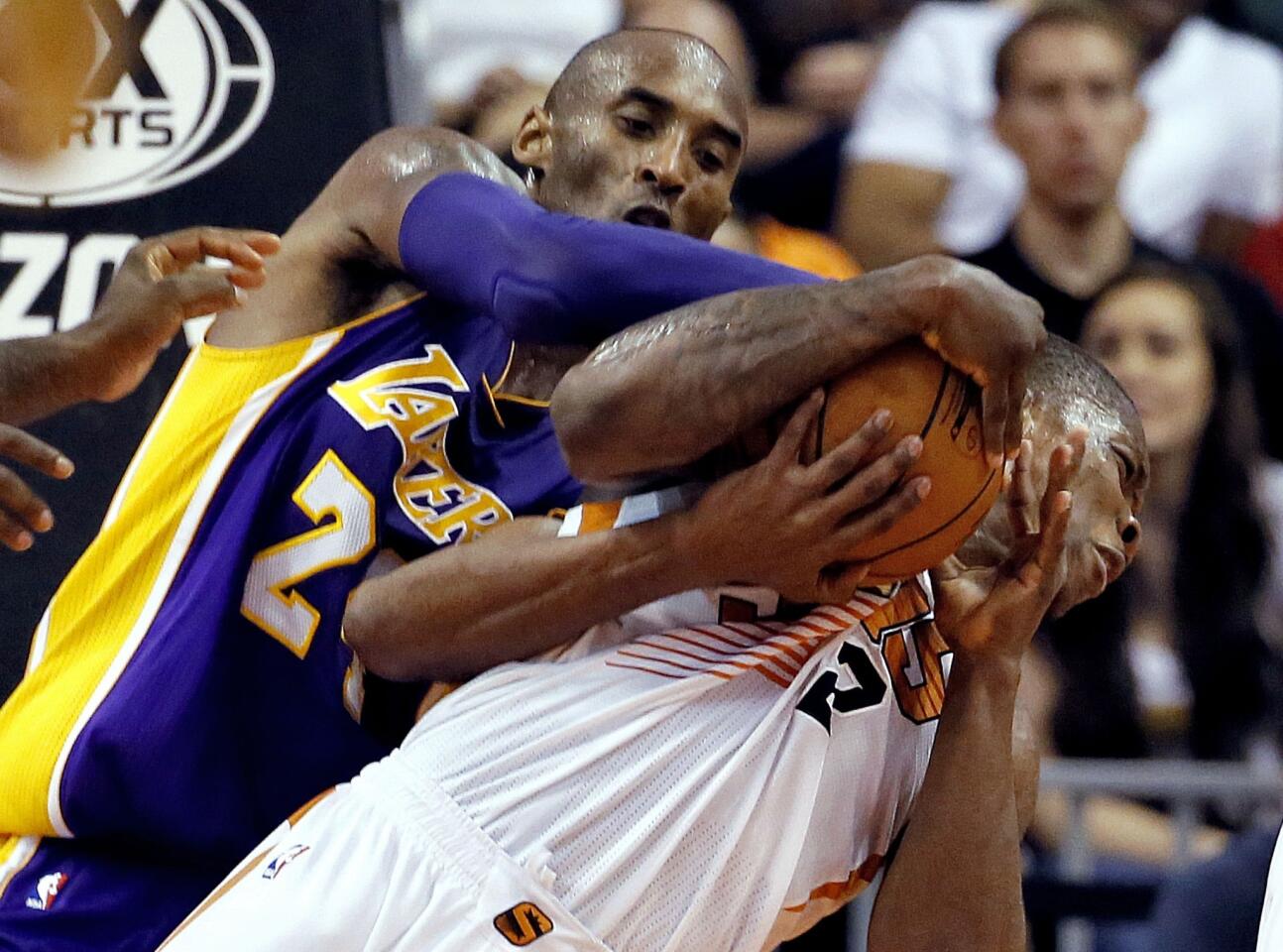 Lakers guard Kobe Bryant and Suns point guard Eric Bledsoe battle for the ball in the second half.