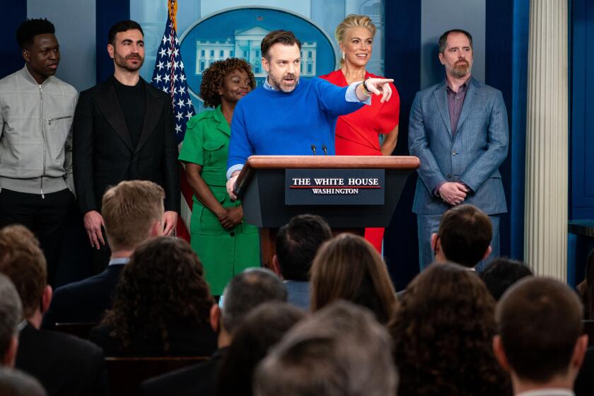 WASHINGTON, DC - MARCH 20: Actor Jason Sudeikis, of "Ted Lasso," points to fellow cast member Jason Lance while speaking during the press briefing with fellow Ted Lasso cast members (L to R) Toheeb Jimoh, Brett Goldstein, Hannah Waddingham, and Brendan Hunt for the daily press briefing with Press Secretary Karine Jean-Pierre at the White House on Monday, March 20, 2023 in Washington, DC. (Kent Nishimura / Los Angeles Times)