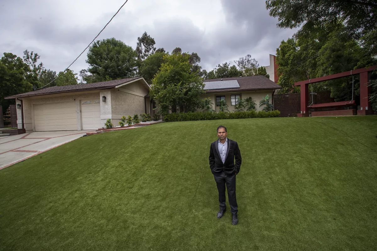 Developer Akhilesh Jha standing on a lawn in front of a single family home