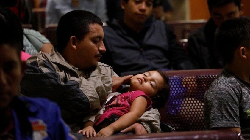 Erazo Varela, 28, of Honduras comforts his ill daughter Kinberlin Erazo, 3, while joining recently released migrants who wait to catch a bus in McAllen, Texas, on April 3.