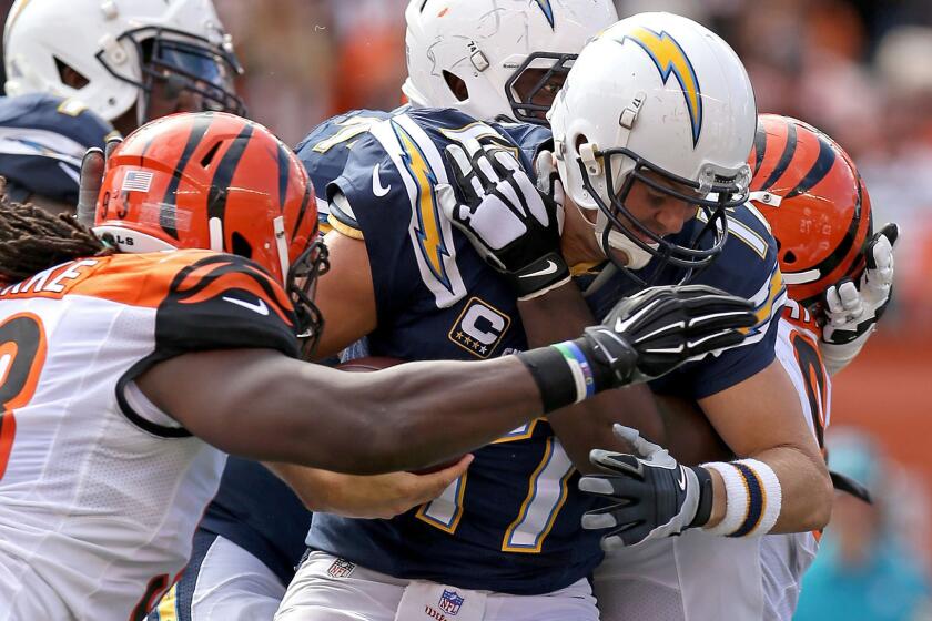 Chargers quarterback Philip Rivers is sacked by Bengals defensive linemen Will Clarke (93) and Geno Atkins in the second half Sunday in Cincinnati.