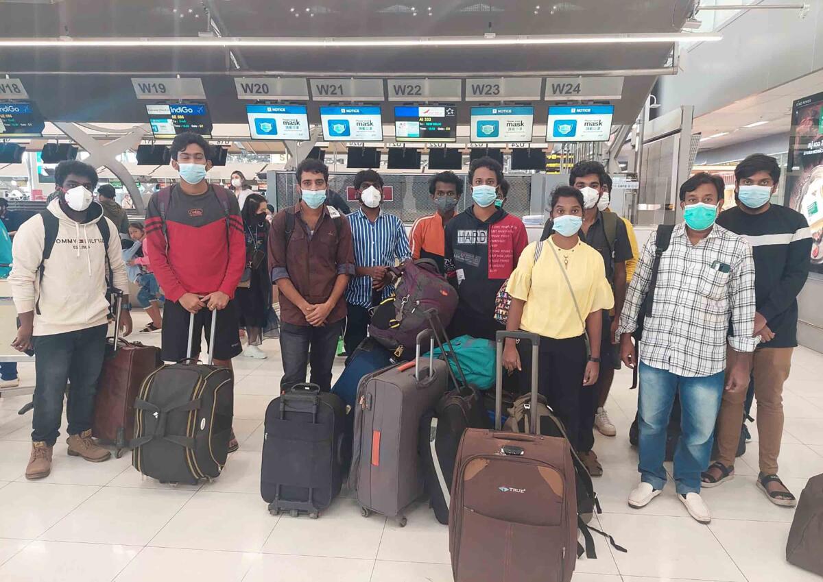 In this photo provided by the Ministry of External Affairs, Indian workers rescued after they were lured by agents for fake job opportunities in the information technology sector in Thailand arrive at the airport in Chennai, India, Wednesday, Oct. 5, 2022. Arindam Bagchi, the External Affairs Ministry spokesperson, said some fraudulent IT companies appear to be engaged in digital scamming and forged cryptocurrencies. The Indian workers were held captive and forced to commit cyber fraud, he told reporters. (Ministry of External Affairs via AP)