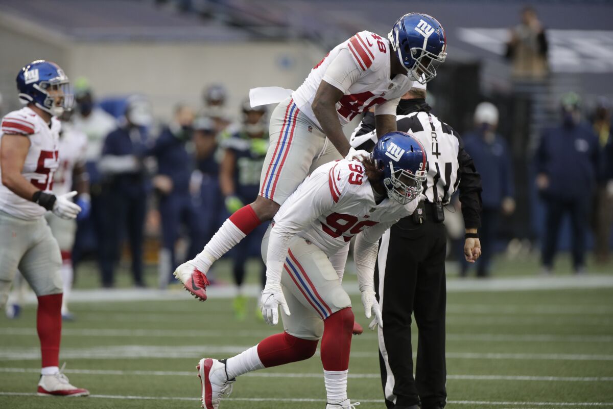 New York Giants defensive end Leonard Williams (99) celebrates with linebacker Tae Crowder (48) after Williams sacked Seattle Seahawks quarterback Russell Wilson (not shown) during the second half of an NFL football game, Sunday, Dec. 6, 2020, in Seattle. (AP Photo/Larry Maurer)