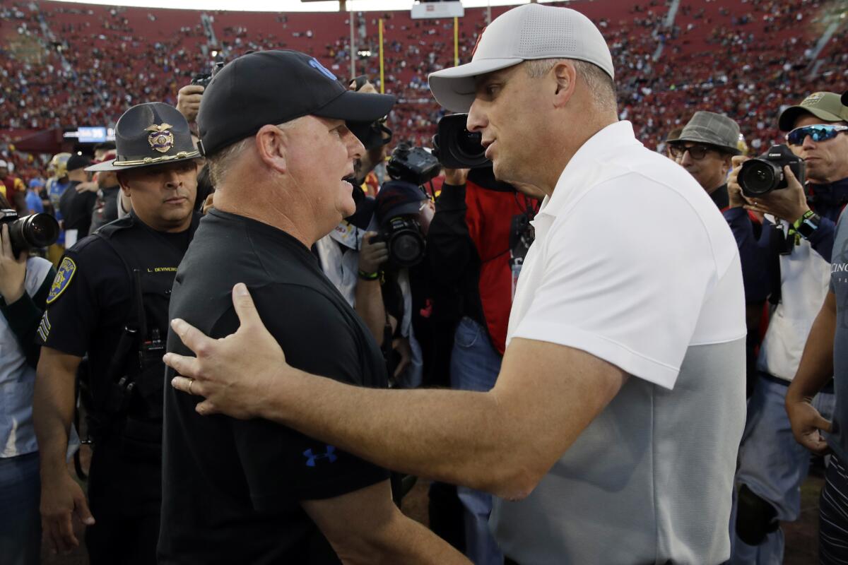 UCLA coach Chip Kelly shakes hands with USC coach Clay Helton after a game.