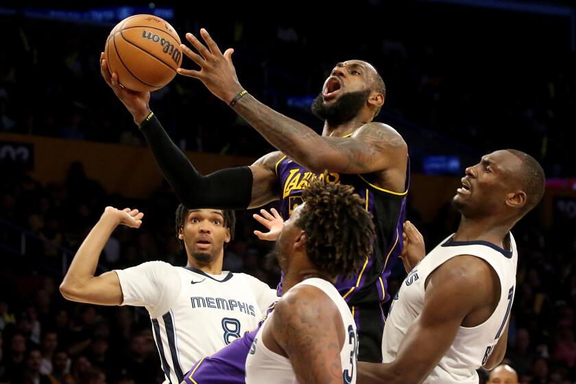 Los Angeles, CA - Lakers forward Lebron James drives to the basket against a trio of Grizzlies defenders.