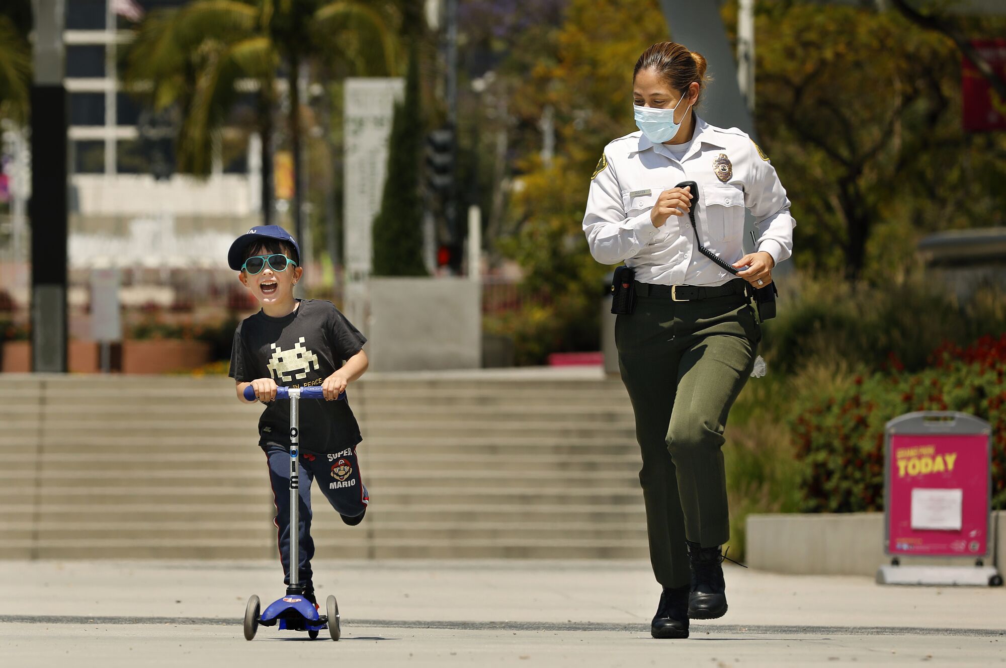 Patton Soole, 5, left, shares a friendly race with L..A County Sheriff's Deputy Bridget Adams at Grand Park in downtown Los Angeles.