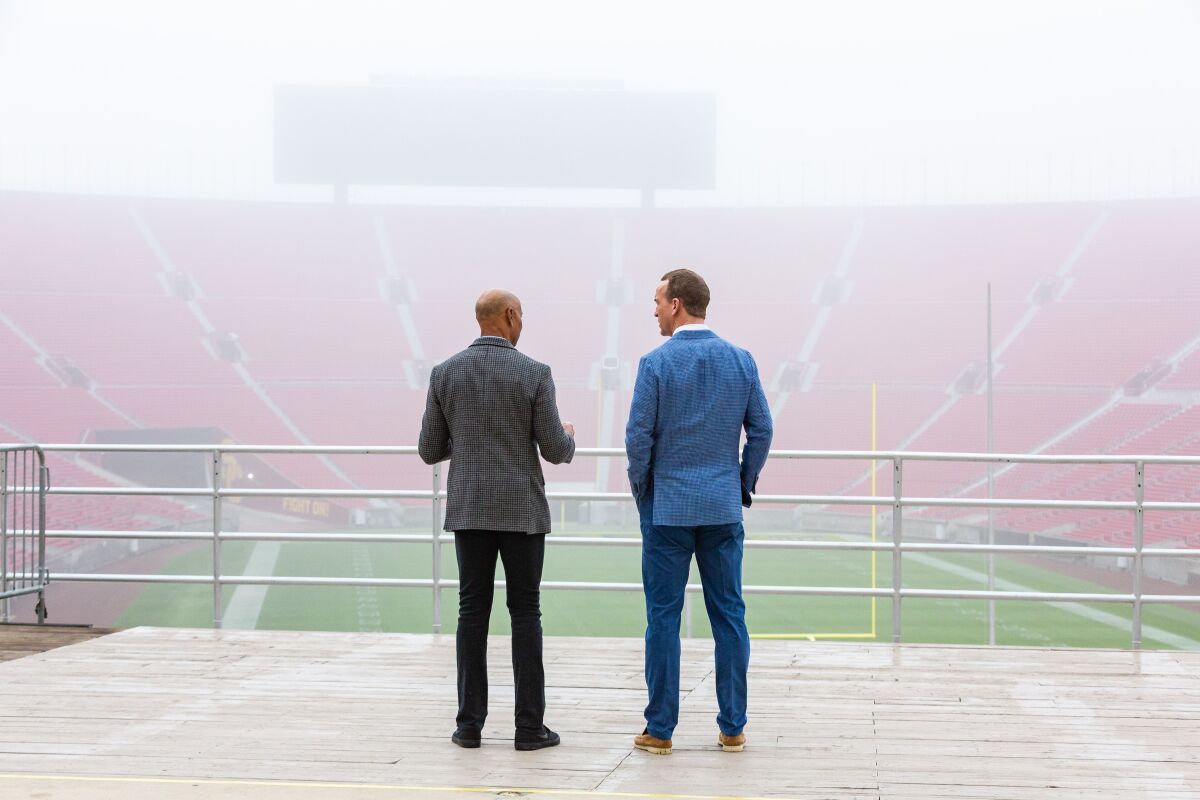 James Lofton and Peyton Manning look out over the field at the Coliseum while shooting an episode of "Peyton's Places."