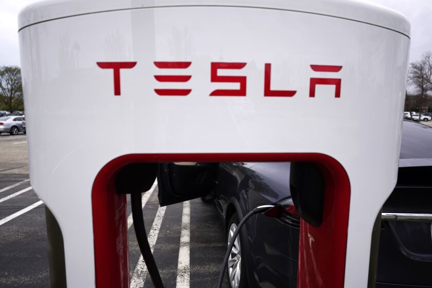 FILE - Tesla Supercharger is seen at Willow Festival shopping plaza parking lot in Northbrook, Ill., on May 5, 2022. New electric vehicle models from multiple automakers are starting to chip away at Tesla's dominance of the U.S. EV market, according to national vehicle registration data. (AP Photo/Nam Y. Huh, File)