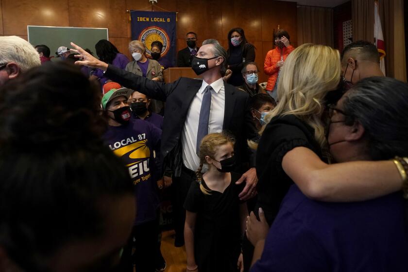 Gov. Gavin Newsom, middle, gestures toward supporters with his daughter, Brooklynn, after speaking to volunteers in San Francisco, Tuesday, Sept. 14, 2021. The recall election that could remove California Democratic Gov. Newsom is coming to an end. Voting concludes Tuesday in the rare, late-summer election that has emerged as a national battlefront on issues from COVID-19 restrictions to climate change. (AP Photo/Jeff Chiu)