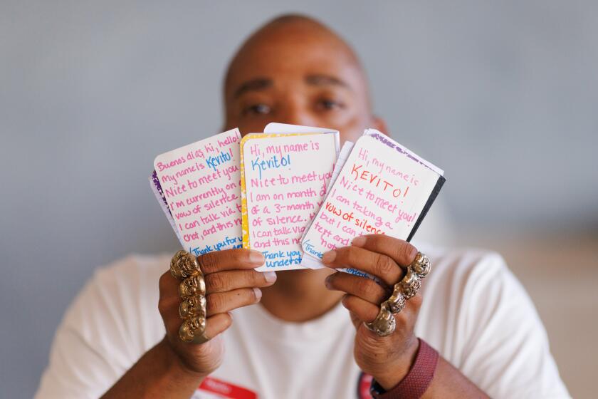 Los Angeles, CA - August 19: Kevito Clark, who took a vow of silence from June 2024 - Sept. 2024, sits at ORA while holding notepads he uses to communicate in Leimert Park on Monday, Aug. 19, 2024 in Los Angeles, CA. (Carlin Stiehl / For the Times)