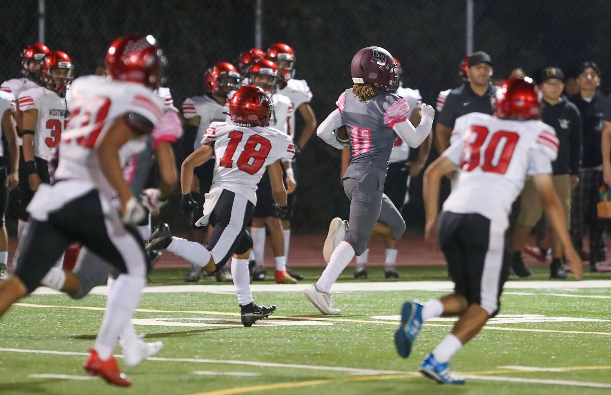 Laguna Beach's Jackson Rodriquez returns a kick for a touchdown during Pac 4 League football game against Westminster.