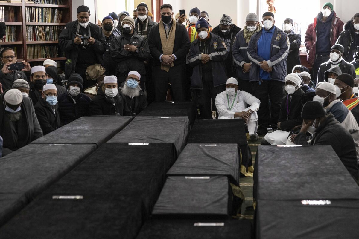 Caskets sit on the floor during the funeral service for victims from the apartment building which suffered the city's deadliest fire in three decades, at the Islamic Cultural Center for the Bronx on Sunday, Jan. 16, 2022, in New York. (AP Photo/Yuki Iwamura)