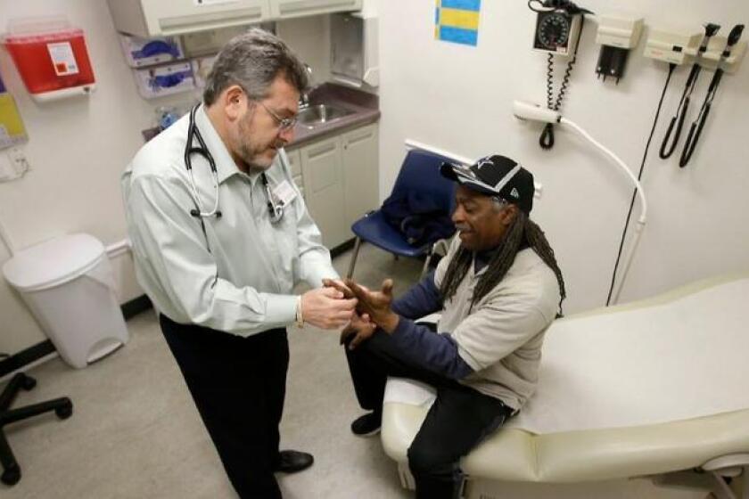 Dr. Leonid Basovich examines Michael Epps, who receives Medicaid insurance coverage, at the WellSpace Clinic in Sacramento.