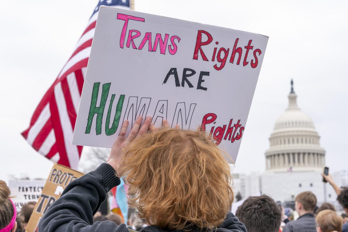 ARCHIVO - Gente asiste a un acto en el Día de Visibilidad Transgénero frente al Capitolio, Washington, 