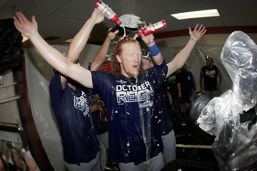 Dodgers pitcher Dustin May is doused during a locker-room celebration after a victory over Baltimore on Tuesday. The Dodgers won 7-3, clinching their seventh consecutive NL West title.