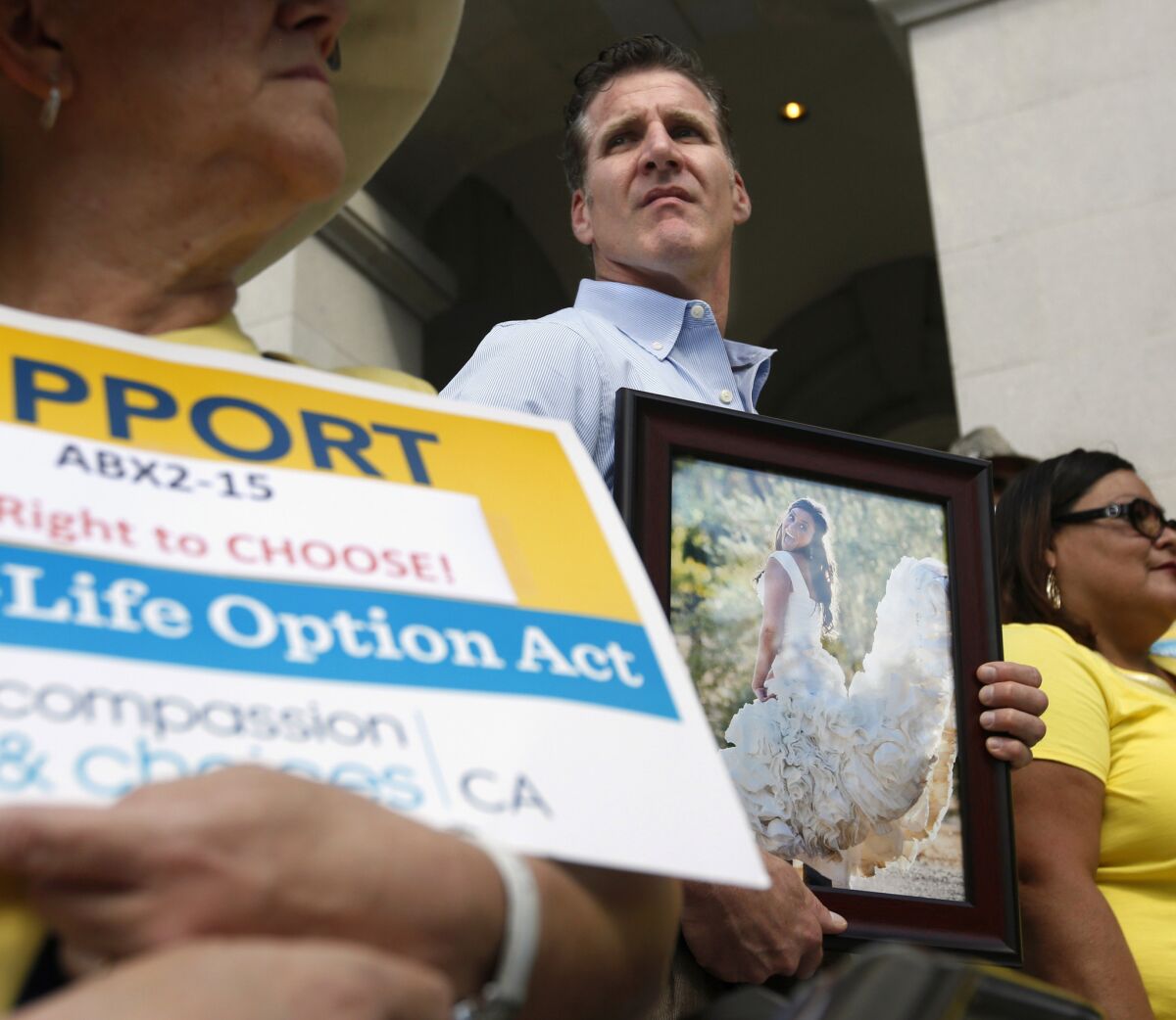 Dan Diaz holds a photo of his late wife, Brittany Maynard, during a rally in September in favor of the End of Life Option Act in Sacramento. A majority of California voters support the measure, according to a new poll. Gov. Jerry Brown signed it into law on Monday.