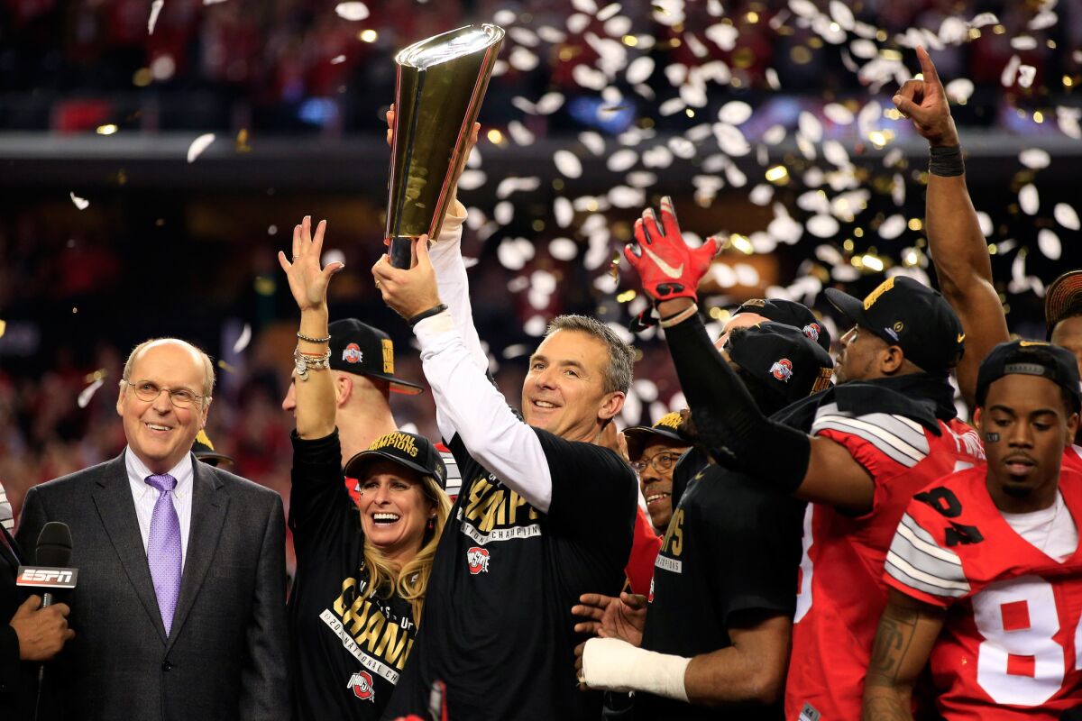 Ohio State Coach Urban Meyer raises the College Football Playoff championship trophy after the Buckeyes' 42-20 victory over Oregon on Monday night at AT&T Stadium in Arlington, Texas.