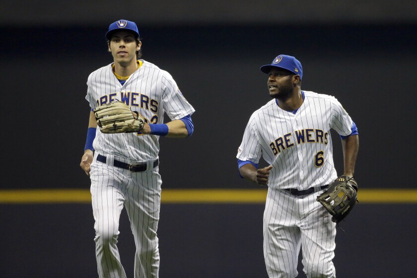 FILE - In this May 24, 2019, file photo, Milwaukee Brewers' Lorenzo Cain runs into the dugout with Christian Yelich after making a catch during the fifth inning of a baseball game against the Philadelphia Phillies in Milwaukee. Milwaukee activated 2018 NL MVP Yelich and fellow outfielder Cain from the injured list and put both in the starting lineup for a game with the Phillies, Monday, May 3, 2021. (AP Photo/Aaron Gash, File)