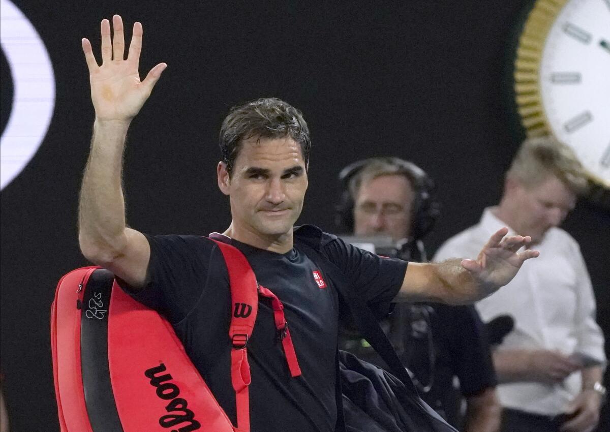 Roger Federer waves as he walks off the court after a match at the Australian Open