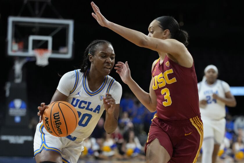 UCLA's Charisma Osborne (20) drives into Southern California's Tera Reed (3) during the first half of an NCAA college basketball game in the first round of the Pac-12 women's tournament Wednesday, March 2, 2022, in Las Vegas. (AP Photo/John Locher)