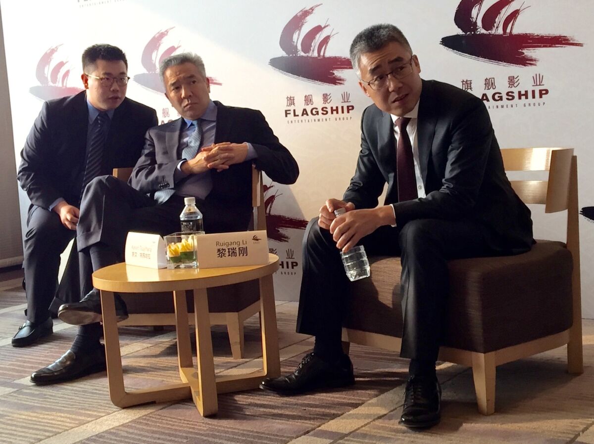 China Media Capital's Li Ruigang, right, and Warner Bros. chief executive Kevin Tsujihara, center, discuss the slate of their new joint venture, Flagship Entertainment, in Beijing.