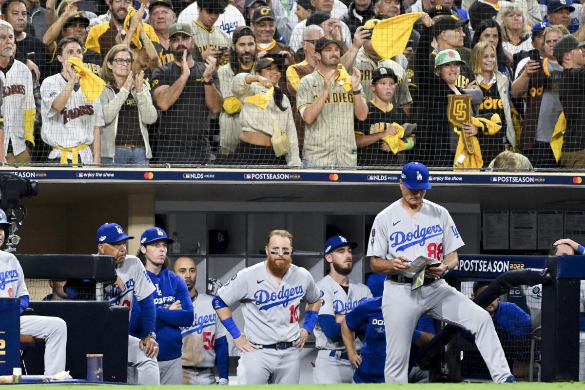 Dodgers players watch from the dugout during the ninth inning in Game 3 of the NLDS against the Padres on Friday.