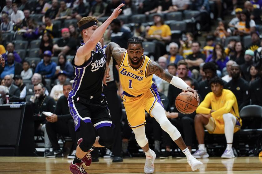 Los Angeles Lakers guard D'Angelo Russell, right, drives against Sacramento Kings guard Kevin Huerter during the first half of a preseason NBA basketball game Wednesday, Oct. 11, 2023, in Anaheim, Calif. (AP Photo/Ryan Sun)