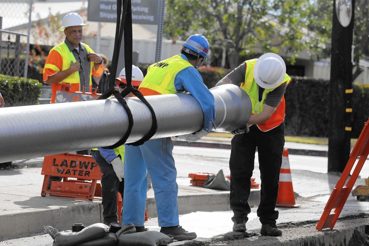 L.A. Department of Water and Power workers install an earthquake-resistant water pipe in Northridge in January. DWP engineers estimate it will cost $15 billion to bolster water pipes throughout the city.