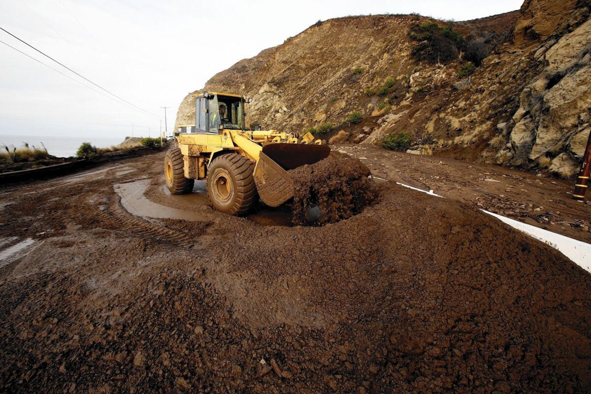 Work crews remove mud and debris from a mudflow that closed Pacific Coast Highway between Las Posas and Yerba Buena roads in Ventura County in December 2014.