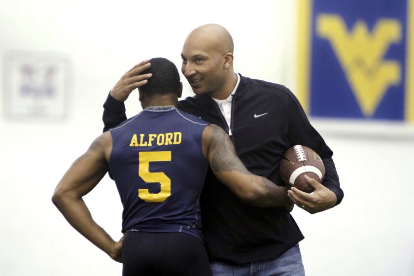 Then-West Virginia assistant coach Lonnie Galloway congratulates wide receiver Mario Alford during the school's NFL pro day in 2015. Louisville has suspended Galloway for the Citrus Bowl.
