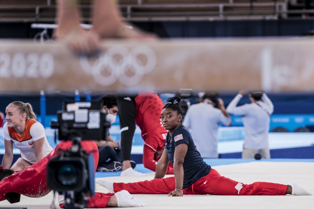 Simone Biles does the splits on a mat.