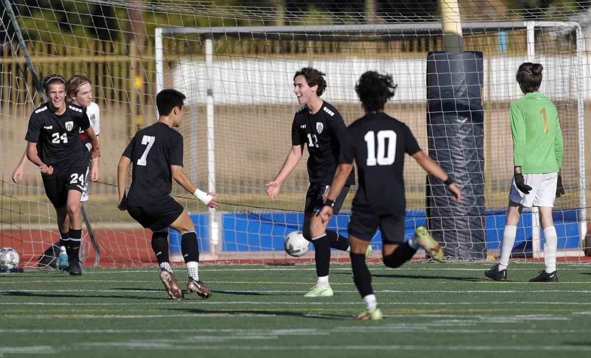 Marina's Tyler Hyde (12) reacts to scoring the game's second goal with David Hallworth (7) against Laguna Beach on Friday.