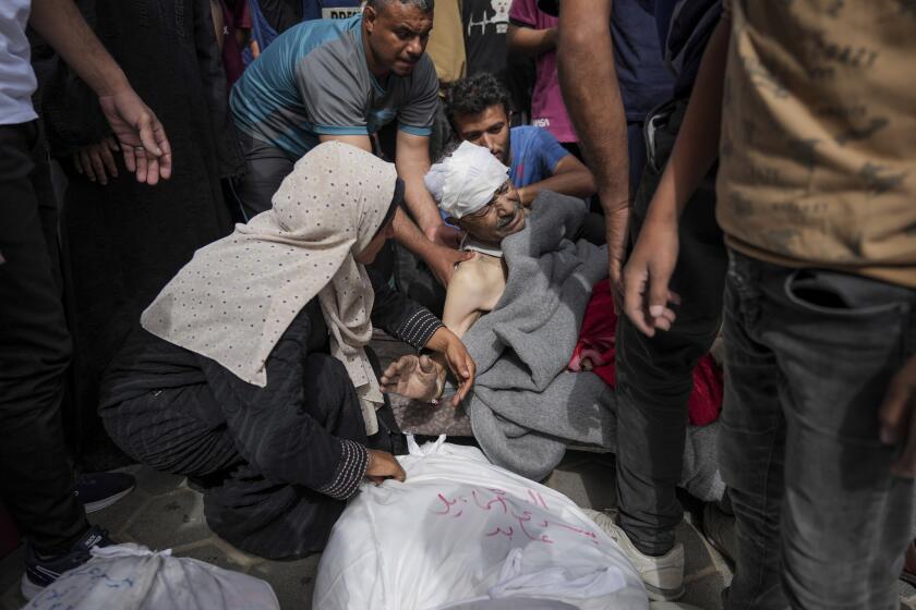 Palestinians mourn relatives killed in the Israeli bombardments of the Gaza Strip in front of the morgue of the Al Aqsa Hospital in Deir al Balah, Gaza Strip, on Saturday, May 11, 2024. (AP Photo/Abdel Kareem Hana)