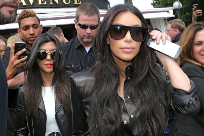 Kim Kardashian, front, meant to have fun with sisters Kourtney Kardashian, left, and Khloe Kardashian during an interview. But her comments were taken out of context, she says.