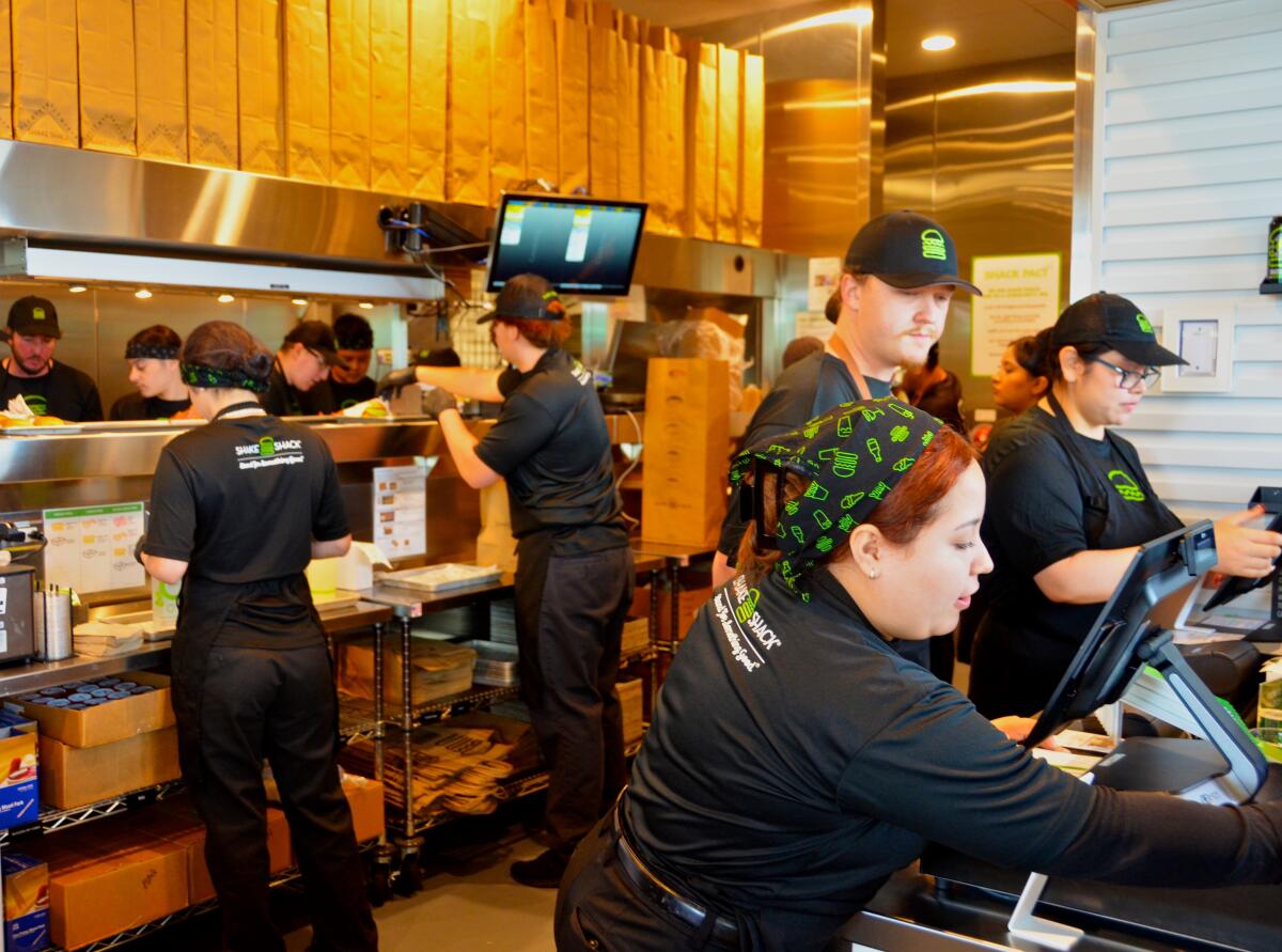 Shake Shack employees take care of hungry customers during the eatery's grand opening in Costa Mesa.