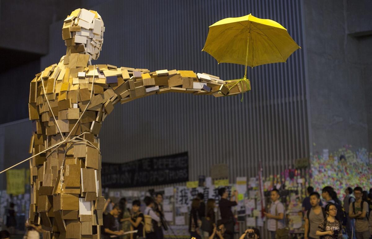 The 'Umbrella Man' sculpture stands over pro-democracy demonstrators outside Hong Kong's Central Government Office on Oct. 8. The demonstrations have produced some interesting art.