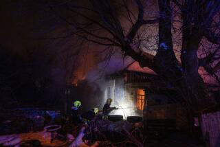 Rescue workers extinguish a fire at a residential house after a Russian rocket attack in Kyiv, Ukraine, Wednesday, Dec. 13, 2023. (AP Photo/Evgeniy Maloletka)