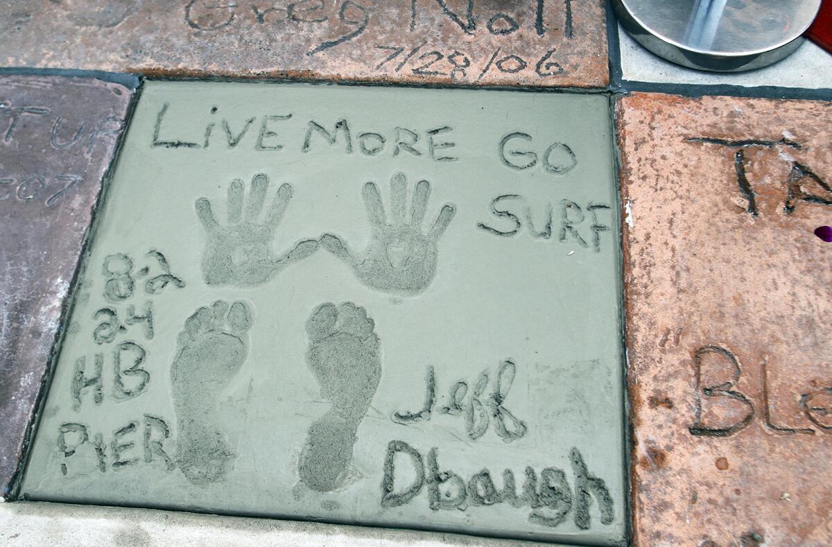 Local Jeff Deffenbaugh wrote "Live More Go Surf" in cement for the 2024 Surfers' Hall of Fame ceremony on Friday.