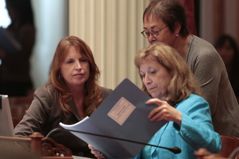 Democratic state Sens. Noreen Evans of Santa Rosa, left, Ellen Corbett of San Leandro, right, and Carol Liu of Pasadena, standing, look over papers at the Capitol in Sacramento.