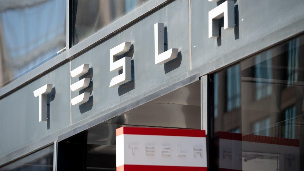 The Tesla logo is seen outside of a showroom in Washington.