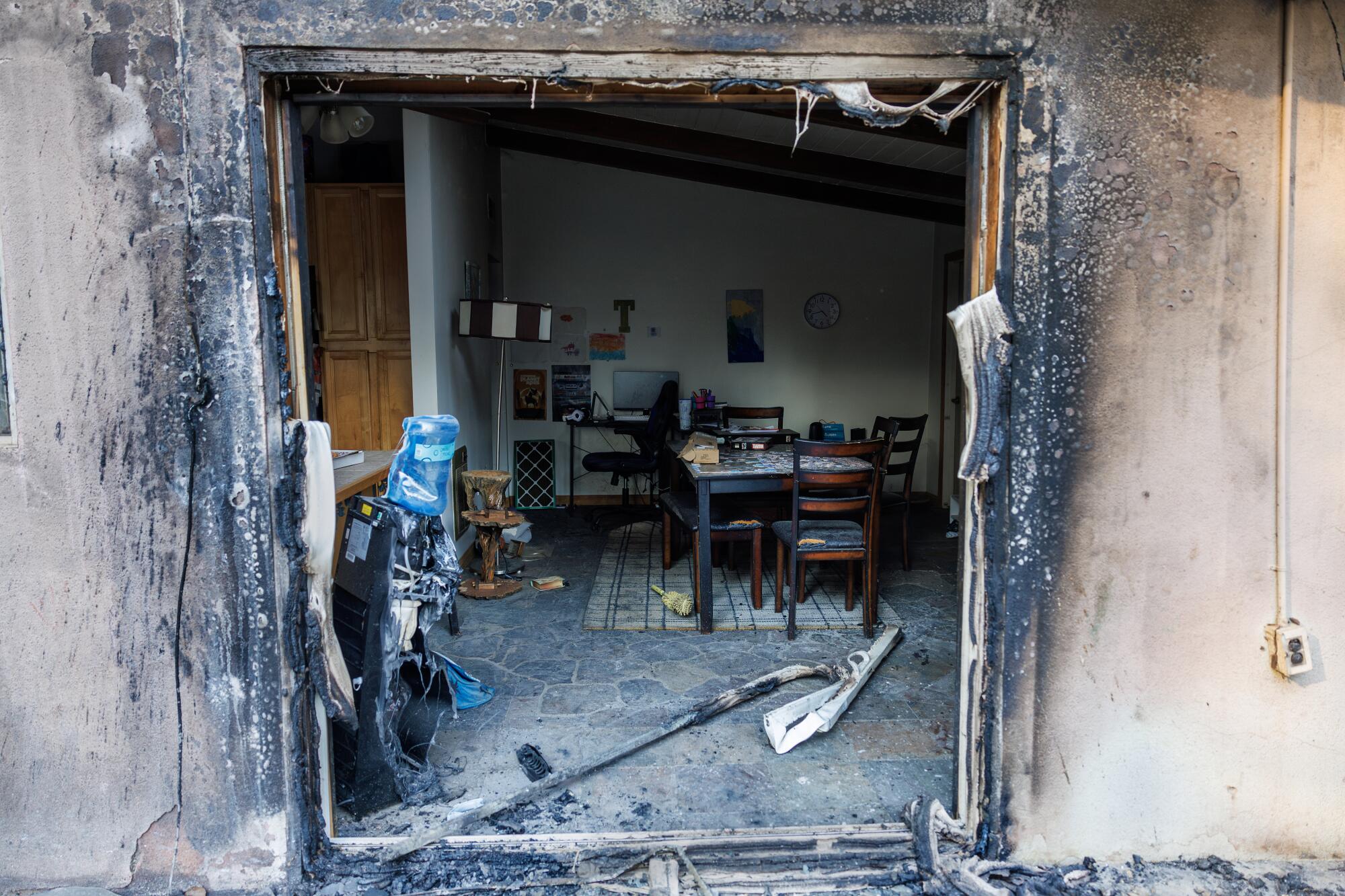 A blackened entryway opens into a room with tables and chairs and a blue water dispenser